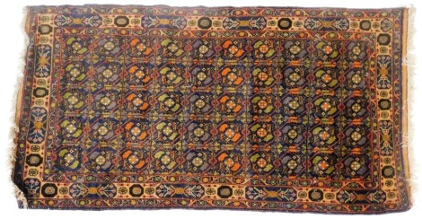 A Shirvan blue ground rug, with fifty central floral repeating medallions, within repeating floral borders, 206cm x 110cm.