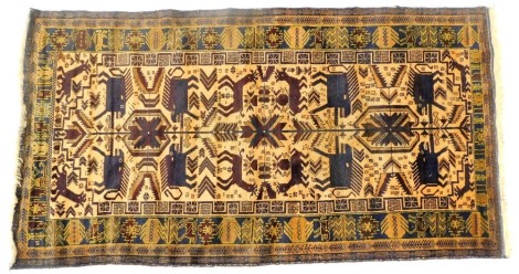 A Pakistani cream ground rug, decorated centrally with wild beasts and flowers, within repeating geometric floral and animal motif borders, 215cm x 114cm.