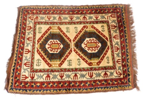 A Turkish Kilim cream ground rug decorated with two central medallions within repeating floral and foliate borders, 182cm x 137cm.