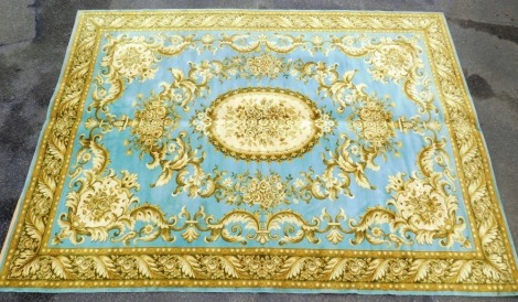 An Aubusson type blue ground rug, decorated in gold with a central floral medallion, within a border of scrolling leaves and flowers, and further floral repeating outer border, 254cm x 346cm.