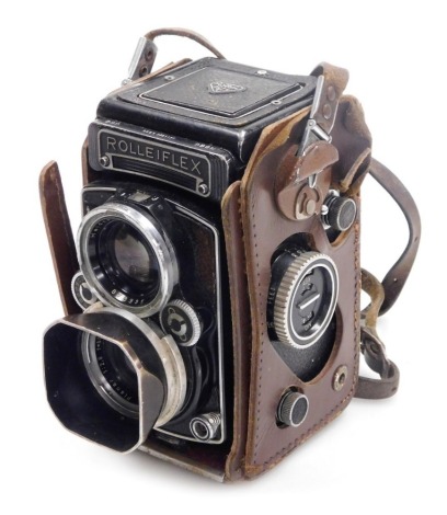 A Franke and Heidecke Rolleiflex twin lens reflex camera, with a Carl Zeiss planar 1:2,8 lens, and a Heidosmat lens 1:2,8/80, number 2361177, with partial leather casing. 