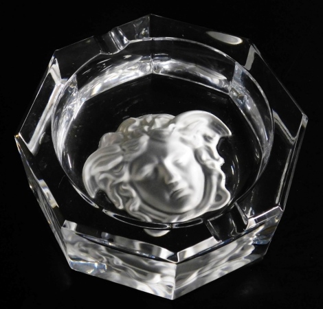 A Rosenthal Versace cut glass ashtray, of octagonal form, with a frosted cameo glass Versace emblem to the base, boxed, 16cm wide.