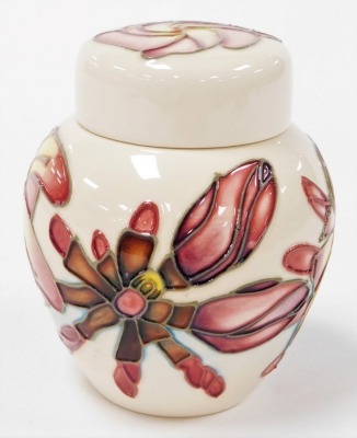 A Moorcroft Frangipani pattern pottery jar and cover, printed marks and signed to underside, 11cm high, boxed. - 2