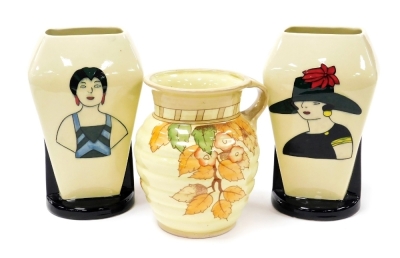 Three items of Crown Ducal Charlotte Rhead pottery, comprising a jug decorated with leaves and flowers against a yellow ground, 19cm high, and a pair of vases decorated to front with depictions of ladies in 1920's dress, and verso with flowers, 24cm high.