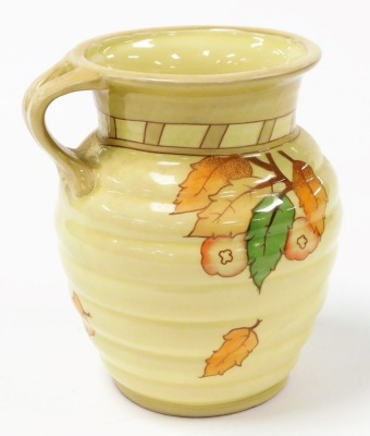 Three items of Crown Ducal Charlotte Rhead pottery, comprising a jug decorated with leaves and flowers against a yellow ground, 19cm high, and a pair of vases decorated to front with depictions of ladies in 1920's dress, and verso with flowers, 24cm high. - 4