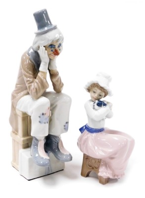 A Lladro porcelain figure of a Pierrot, modelled seated with his head in his hands, together with a Nao figure of a girl with a puppy seated on a stool. (2)