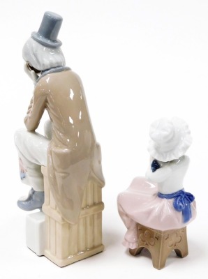 A Lladro porcelain figure of a Pierrot, modelled seated with his head in his hands, together with a Nao figure of a girl with a puppy seated on a stool. (2) - 2