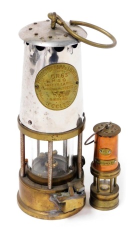 A Protector Lamp and Lighting Company Limited brass and aluminium miners lamp, type GR6S, number 537, 26cm high, together with a Sunderland miniature copper and brass miners lamp, number 25, 12cm high. (2)