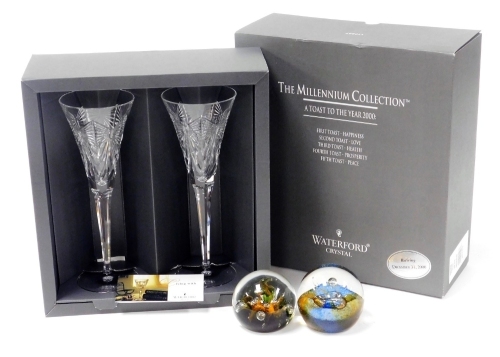 A pair of Waterford Millennium Collection crystal champagne flutes, a toast to the year 2000, boxed, together with a Caithness Cosomos paperweight, and a further paperweight. (3)