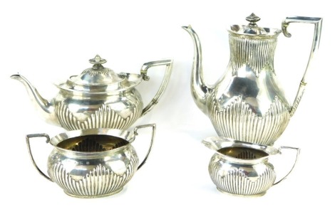 An Edward VII silver four piece tea service, with part fluted body and urn finial, with acanthus leaf terminal to the handle, Barker Brothers, Birmingham 1904, 50½oz gross.