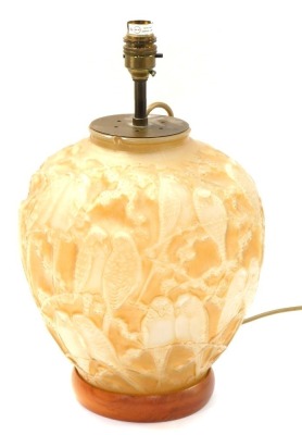 A 1920's Phoenix Glass Company Art Deco table lamp, with a moulded yellow glass shade depicting budgerigars and branches, on a turned wooden base, drilled, 33cm high.