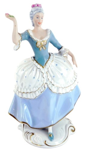 A Royal Dux porcelain figure of a lady, in blue and white spotted dress, picked out in gilt with pink triangle stamp to underside, 23cm high.