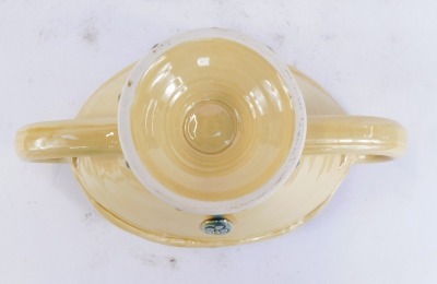 A Fenella Mallalieu studio pottery centre bowl, on a fluted and flared top, on a turquoise and mustard ground, with four point crested flower design, shaped handles, unmarked, 13cm high, 30cm diameter. - 2