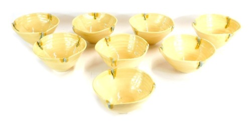 A set of eight Fenella Mallalieu studio pottery bowls, each of three fold form with turquoise and mustard detail, bearing partial signatures, 9cm high, 15cm wide.