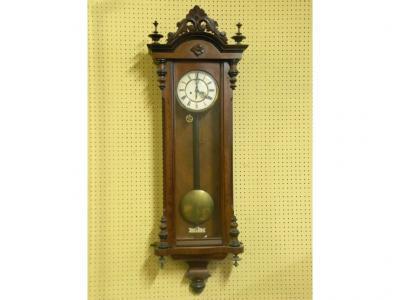 A late 19th/early 20thC Vienna type walnut wall clock with a pierced carved crest