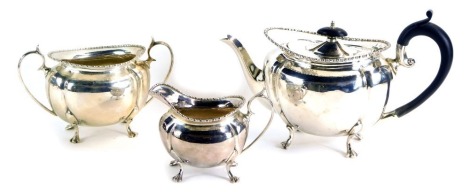 A George V silver three piece tea service, with an ebonised handle and knop, on fluted design, Sheffield 1928, 21¼oz gross.