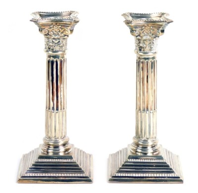 A pair of silver taper candlesticks, each on Corinthian column with scroll design, and vine top, on loaded bases, maker A S, Birmingham 1968, 21oz gross.