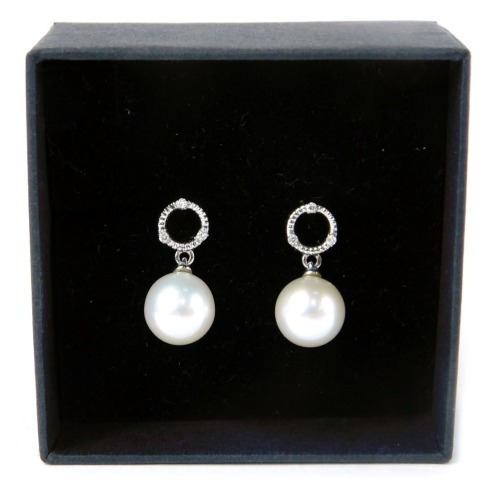 110 - A pair of 9ct white gold pearl and diamond drop earrings, with a circle halo ring, set with three tiny diamonds, on white lustre drops, 8g all in, boxed.