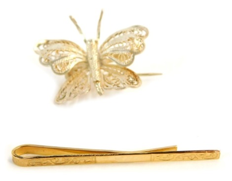 A 9ct gold tie clip, 1.6g, and a filigree white metal butterfly brooch. (2)
