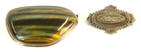 Two brooches, comprising a Victorian silver floral bar brooch, 4cm wide, 3.2g, and a Tiger's Eye brooch, in white metal frame, unmarked, 5.5cm wide. (2)