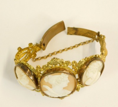 A late 19thC/early 20thC shell cameo bracelet, formed with three oval cameos depicting maidens in flowing headdress, in a gilt bangle frame, with heavy scroll detail, the front section 8cm wide, 6cm high, 37.1g all in. - 2