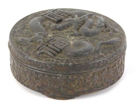 An early 20thC Japanese antimony box, of circular form with dragon and script character design, 7.5cm diameter.