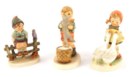 Three Goebel by Hummel figures, comprising Goose Girl, 11cm high, Wayside Harmony, 10cm high, and Kitty Kisses, 11cm high. (3)