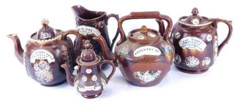 A group of Victorian and later pottery barge wares, comprising three large teapots, small teapot and a jug, each on brown treacle glaze with applied flower and white plaque detail. (AF)