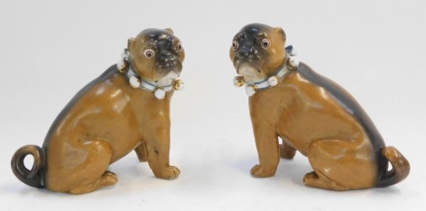 A pair of late 19thC German porcelain models of pugs, each with bells to the collar, number stamped to base, 9cm high.