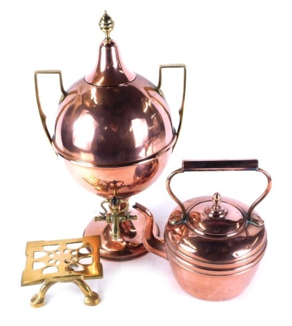 A group of copper and brass wares, a Victorian copper kettle, copper tea urn and a brass trivet. (3)