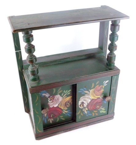 A toleware style green painted cabinet, with a shelf top and two cupboard base painted with flowers, 47cm high, 32cm wide, 19cm deep.