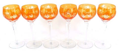 A set of six orange glass hoch glasses, each with an etched star and grape design, on a faceted stem, 19cm high.