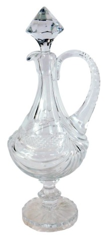 An early 20thC cut glass claret jug, with a diamond shaped stopper, of baluster form, on a shaped handle with swag design to the body, 44cm high.