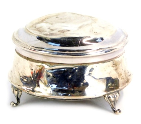 A George V silver jewellery box, of circular form, with a green velvet lined interior, on three scroll feet, Chester 1919, 2¼oz gross.