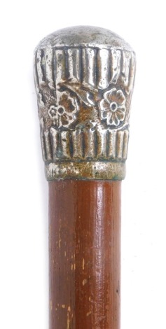 An early 20thC stained pine walking cane, with a plated handle, embossed with flowers, 88cm high.