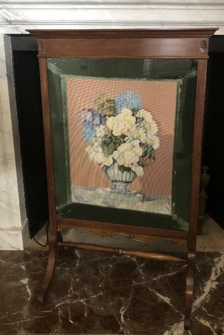 An Edwardian walnut fire screen, with needlework floral panel, 106cm high, 67cm wide.