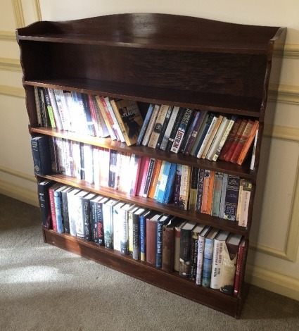 A mahogany open bookcase, with shaped sides and a plinth, 113cm high, 107cm wide, 20cm deep.