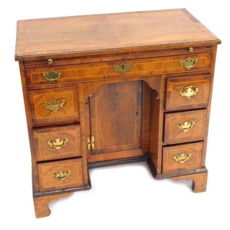 A 19thC walnut kneehole desk, the moulded top above arrangement of one long drawer and three drawers to each pedestal, terminating in bracket feet, 83cm high, 85cm wide, 45cm deep.