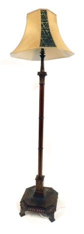 An Edwardian mahogany carved standard lamp, on a square foot, with scroll detail, on four row reeded column, with cream shade, 195cm high. WARNING! This lot contains untested or unsafe electrical items. It is supplied for scrap or re-conditioning only. T