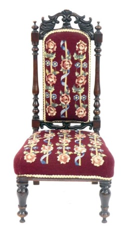 A Victorian mahogany nursing chair, the scroll carved top with a burgundy woolwork tapestry seat, 91cm high.