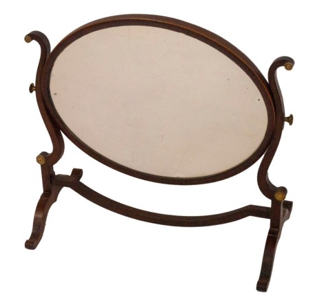 A 19thC mahogany dressing table mirror, with shaped scrolling frame and oval plate with boxwood stringing, 50cm x 54cm.