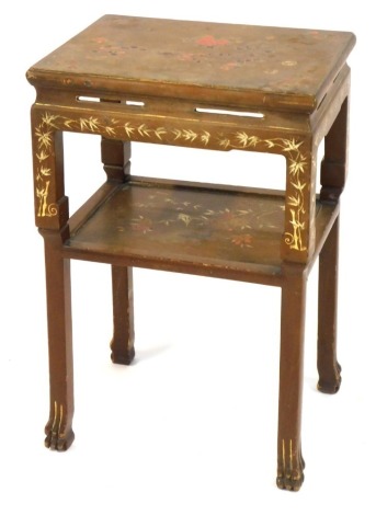 An Oriental lacquer table, of two tiers, on a brown gilt and red painted decoration with blossoms, on paw feet, 70cm high, 45cm wide, 33cm deep.