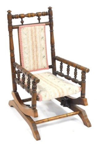 A late 19thC walnut child's rocking chair, with bobbin turned supports and tapestry inlaid seat, 72cm high, 40cm wide, 40cm deep.