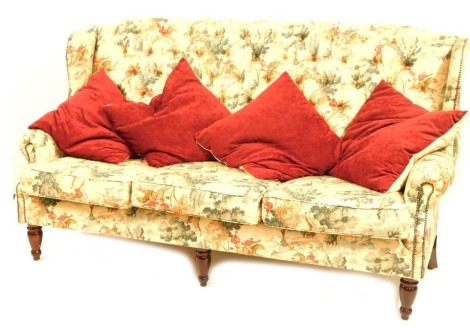 A button back sofa, in a hunting scene upholstery, on mahogany legs, 120cm high, 193cm wide, 65cm deep.