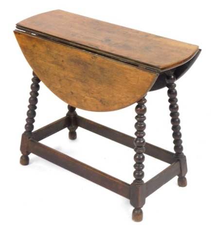 An oak drop leaf table, on H frame base, with bobbin turned supports, 55cm high, 63cm wide, 25cm deep. (AF)