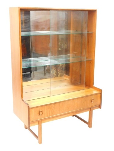 A teak bookcase, with sliding glass top, above single drawer on taper legs, 132cm high, 92cm wide, 42cm deep.