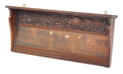 A carved walnut wall shelf, the applied shell top with panel, and glazed back, 34cm high, 72cm wide.