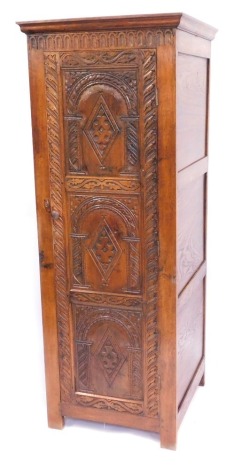 A carved oak hall robe, with a moulded cornice, above three paneled carved door, terminating in stiles, 188cm high, 70cm wide, 69cm deep.