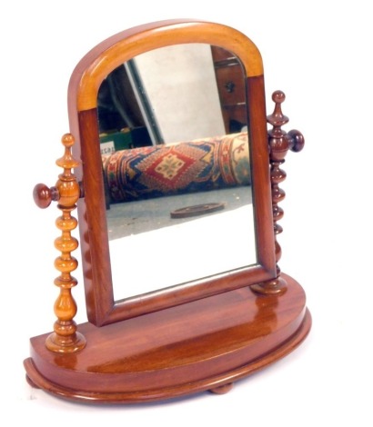 A Victorian mahogany swing framed dressing table mirror, with shaped front on bobbin turned supports, 48cm high, 45cm wide, 18cm deep.