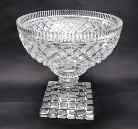 A 20thC crystal footed bowl, with a turreted border, hobnail cut diamond shaped body, compressed stem and stepped square base, unmarked, 27cm high.